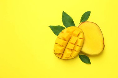 Sarı arkaplanda olgun mango meyvesi, metin için boşluk
