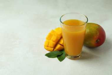 Beyaz desenli masada olgun mango meyvesi ve meyve suyu.