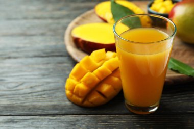 Olgun mango meyvesi ve meyve suyu ahşap masada