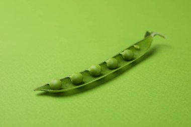 Yeşil arka planda tohumları olan yeşil bezelye kabuğu