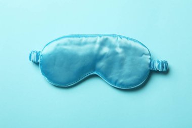 Blue sleep mask on blue background, close up