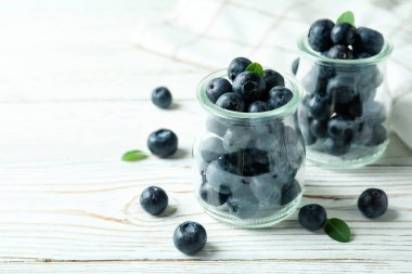 Beyaz ahşap masada yabanmersinli taze böğürtlen konsepti