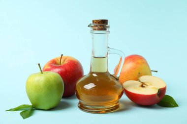 Ev yapımı elma sirkesi ve mavi arka planda malzemeler.