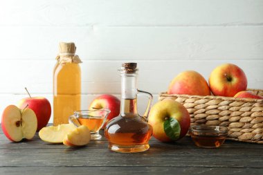 Homemade apple vinegar and ingredients on wooden table