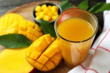 Olgun mango meyvesi ve meyve suyu ahşap masada