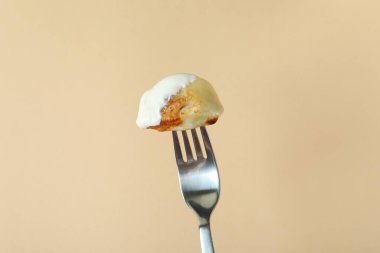 Varenik çatalı ya da bej arka planda pierog.