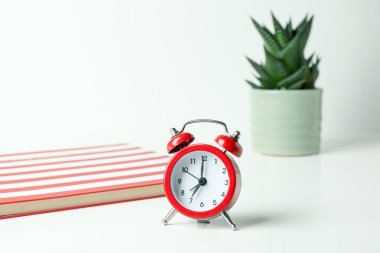 Beyaz arkaplanda alarm saati olan işyeri kavramı