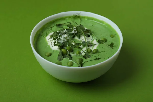 緑の背景にエンドウ豆のスープのボウル — ストック写真
