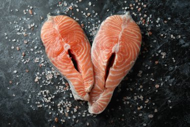 Siyah dumanlı arka planda taze çiğ somon ve tuz.