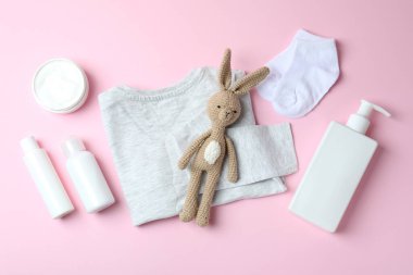 Pembe arka planda farklı bebek hijyeni aksesuarları.