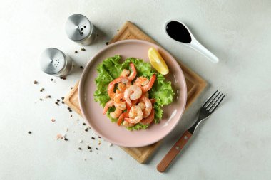 Beyaz desenli masada ızgara karides tabağı.