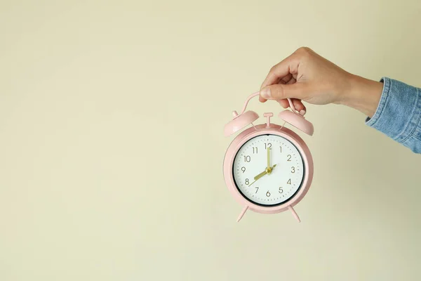 Female Hand Holds Alarm Clock Beige Background — Stockfoto