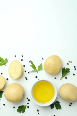 Beyaz arka planda taze patates, baharat ve yağ