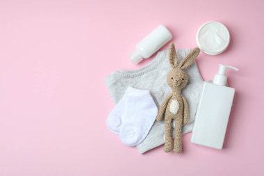 Pembe arka planda farklı bebek hijyeni aksesuarları.
