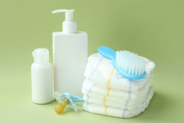 Yeşil arka planda farklı bebek hijyeni aksesuarları.