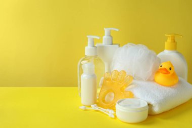 Sarı arka planda farklı bebek hijyeni aksesuarları.
