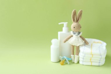 Yeşil arka planda farklı bebek hijyeni aksesuarları.