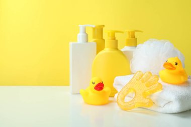 Sarı arka planda farklı bebek hijyeni aksesuarları.