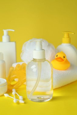 Sarı arka planda farklı bebek hijyeni aksesuarları.