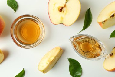 Beyaz arka planda ev yapımı elma sirkesi ve malzemeler