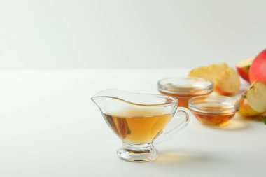 Ev yapımı elma sirkesi ve malzemeler beyaz masada.