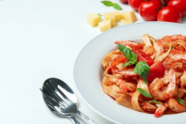 Beyaz zemin üzerinde karides makarna ve malzeme tabağı