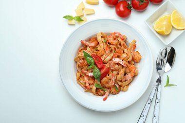 Beyaz zemin üzerinde karides makarna ve malzeme tabağı