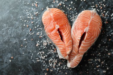 Siyah dumanlı arka planda taze çiğ somon ve tuz.