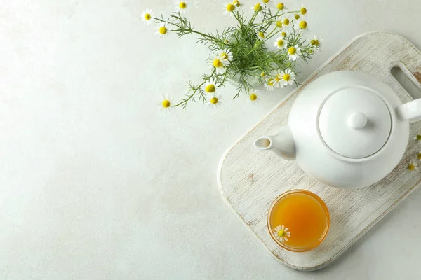 Concept of breakfast with chamomile tea on white textured table