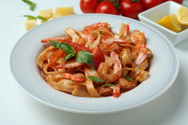 Beyaz zemin üzerinde karides makarna ve malzeme tabağı