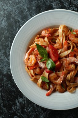 Siyah dumanlı arka planda karides makarna tabağı