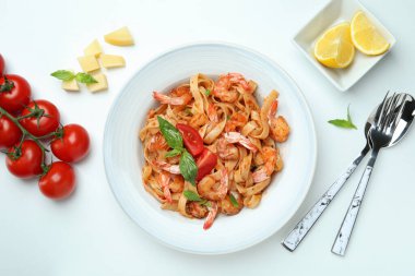 Beyaz zemin üzerinde karides makarna ve malzeme tabağı