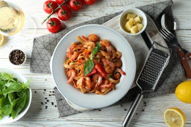 Beyaz ahşap masada karides makarna pişirme kavramı