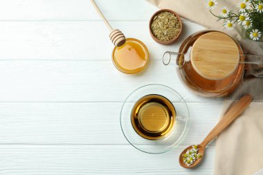 Beyaz ahşap masada papatya çayı pişirme kavramı