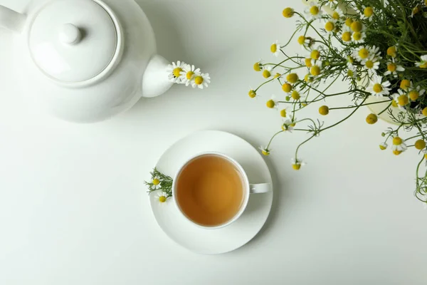 Concept of breakfast with chamomile tea on white table