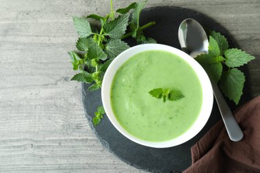 Gri dokulu masada ısırgan otu çorbası ile sağlıklı yemek kavramı