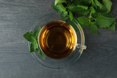 Koyu ahşap masada bir fincan ısırgan otu çayı