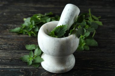 Tahta masada taze ısırgan otu olan havan topu.