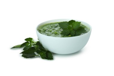 Beyaz arka planda izole edilmiş bir tabak ısırgan otu çorbası.