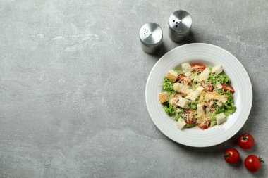 Gri desenli arka planda Sezar salatasıyla lezzetli yemek kavramı