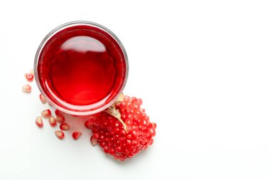 Beyaz arka planda bir bardak nar suyu ve malzeme.