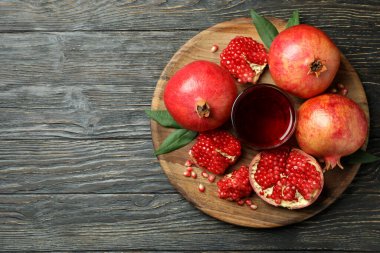 Tahta üzerinde nar suyu ve malzemeler olan tahta bir masa.