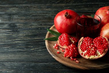 Tahta üzerinde nar suyu ve malzemeler olan tahta bir masa.