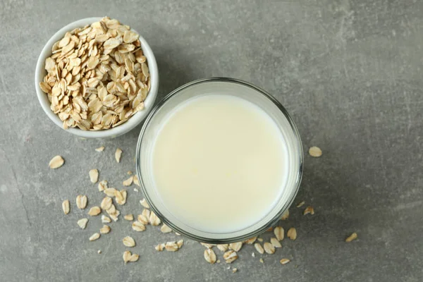 Glass of milk and cereals on gray textured background