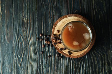 Tahta masada bir bardak buzlu kahve ve fasulye.