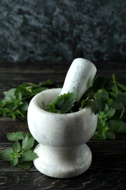 Tahta masada taze ısırgan otu olan havan topu.