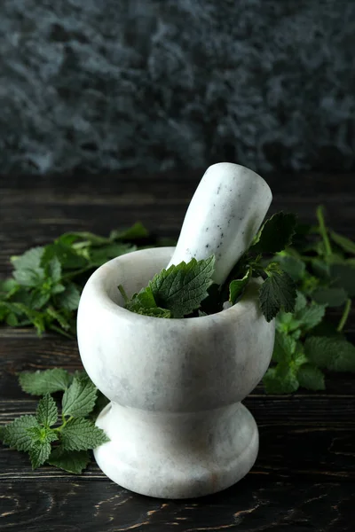 Tahta masada taze ısırgan otu olan havan topu.