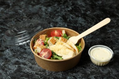 Siyah dumanlı arka planda Sezar salatasıyla lezzetli yemek kavramı