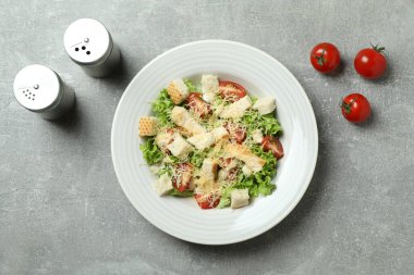 Gri desenli arka planda Sezar salatasıyla lezzetli yemek kavramı