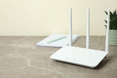 Gri desenli masadaki Wi-fi yönlendiricili işyeri